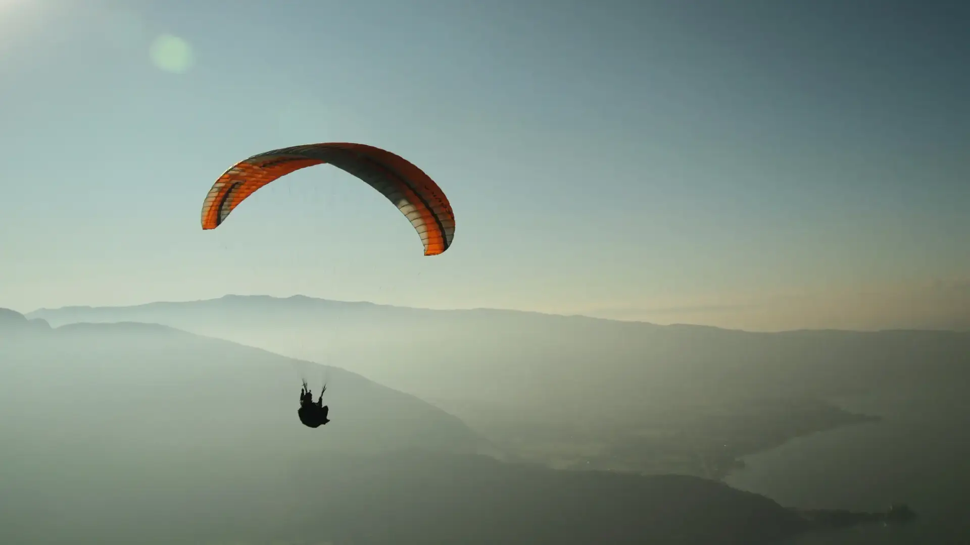 man flying the sky with parachute